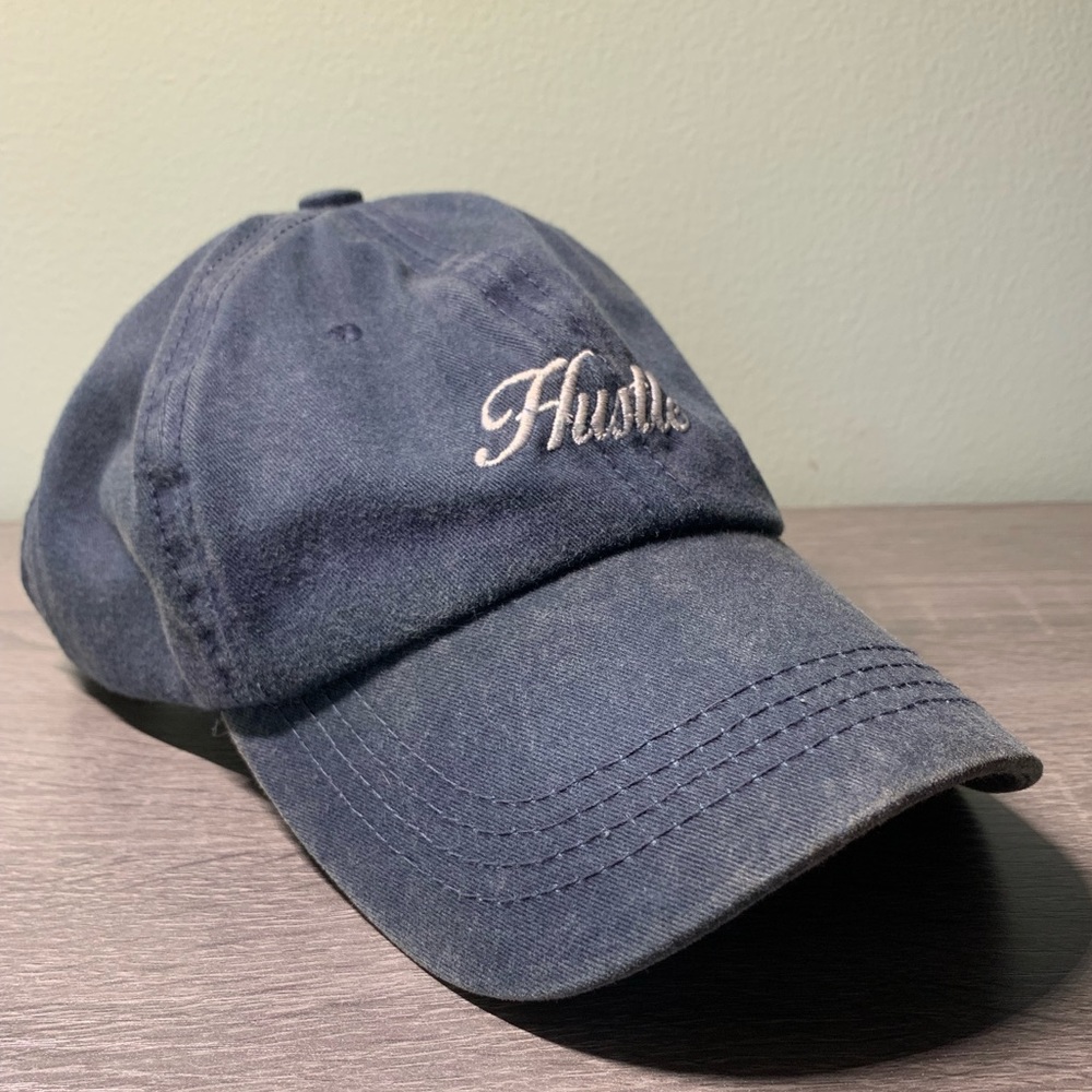 Navy blue hat. “Hustle” printed on the front.